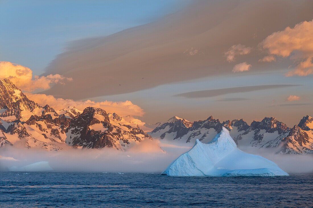 Antarktis, Insel Südgeorgien, Coopers Bay. Eisberg und Berge bei Sonnenaufgang