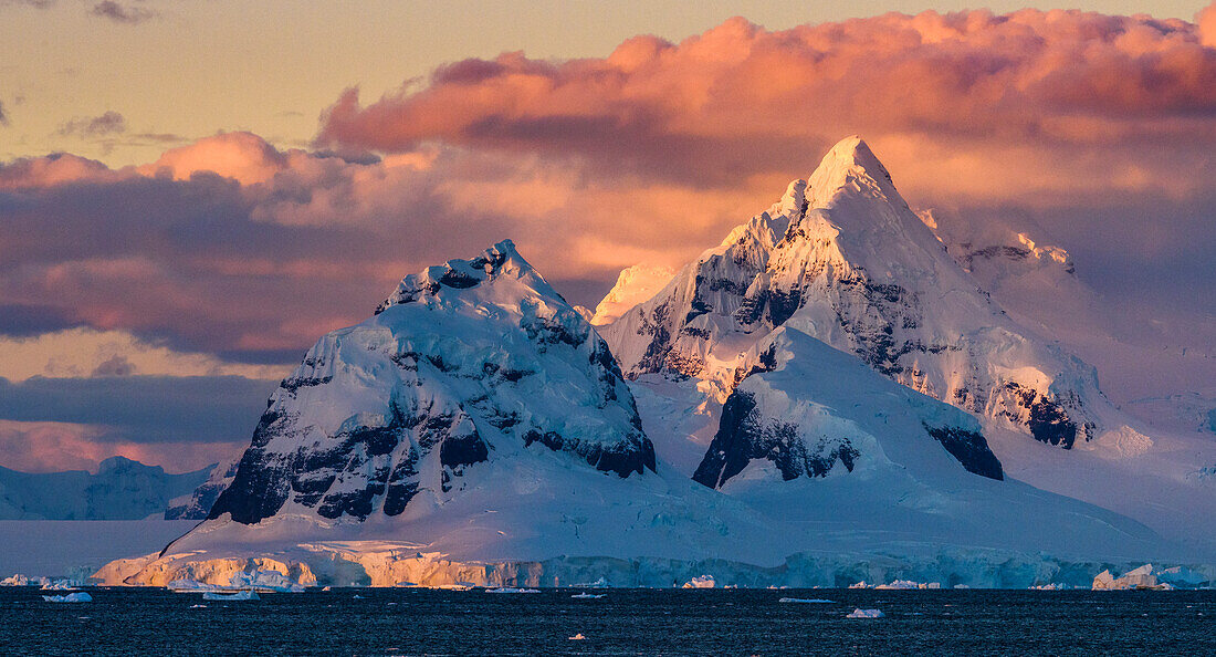 Antarktis, Antarktische Halbinsel, Lemaire-Kanal, vergletschert, Berg bei Sonnenuntergang.