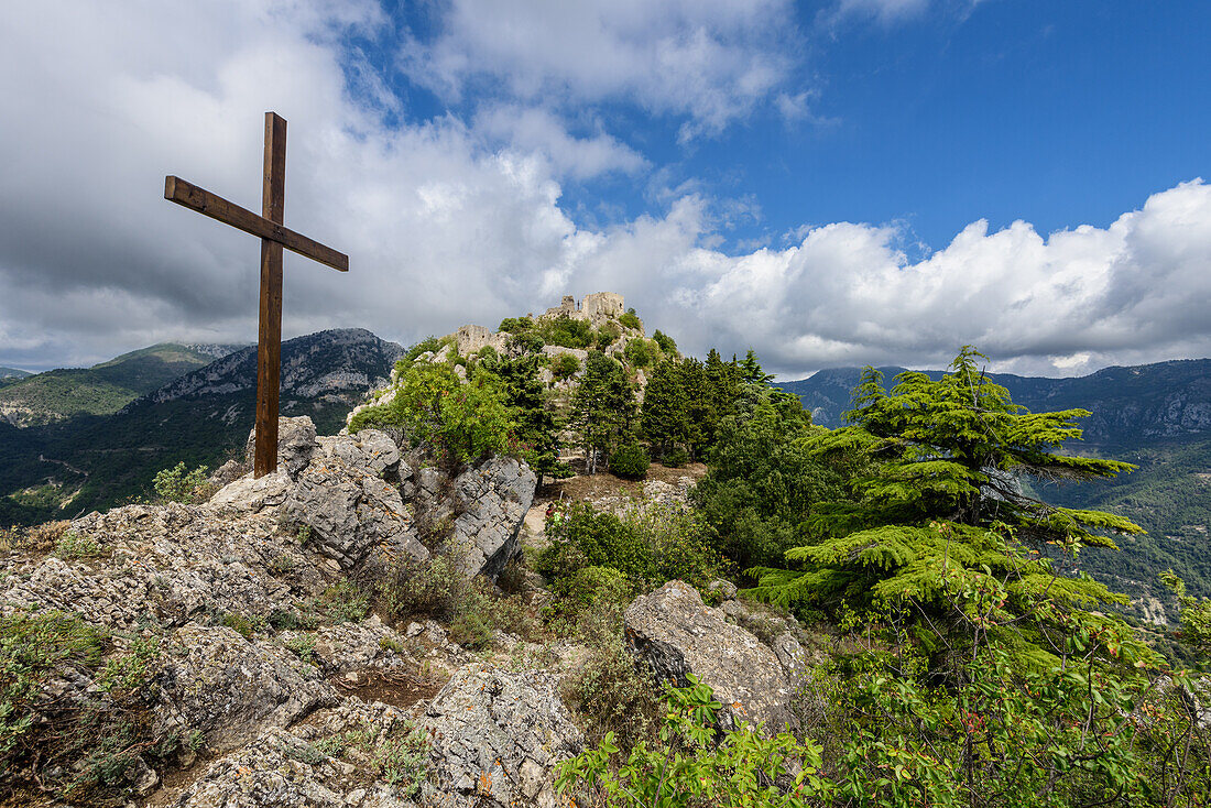 Kreuz und mittelalterliche Burg oberhalb des Bergdorfes Sainte-Agnès in den französischen Seealpen, Provence, Frankreich