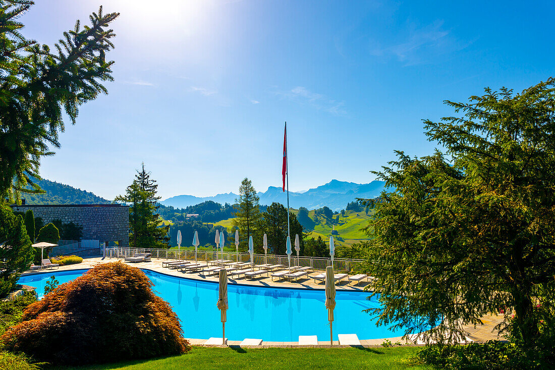 Schwimmbad mit Blick auf die Berge an einem sonnigen Sommertag in Burgenstock, Nidwalden, Schweiz.