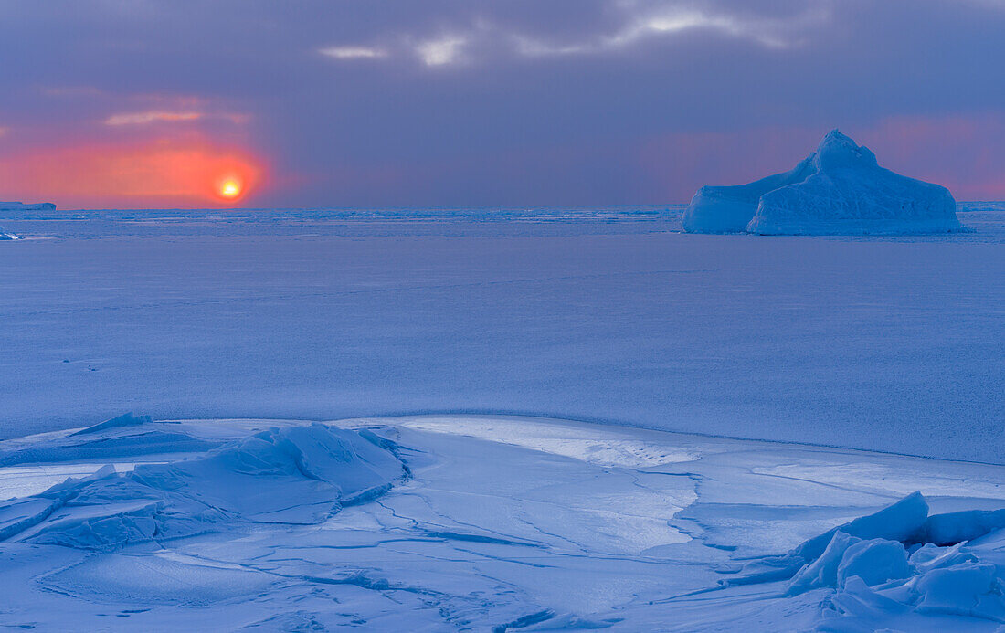 Sunset at the shore of frozen Disko Bay during winter, West Greenland, Denmark