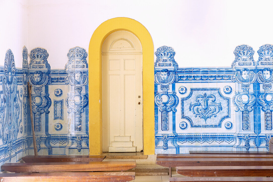 Innenraum der Kathedrale Nossa Senhora da Graça mit blau-weißem Azuleijo-Fries und gelber Tür in São Tomé auf der Insel São Tomé in Westafrika