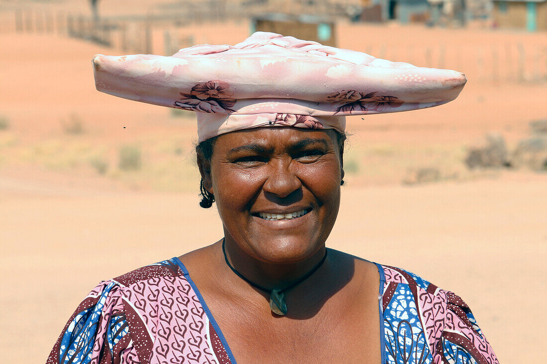 Namibia; Region Kunene; Zentralnamibia; am Ugab Fluss; Herero Frau in traditioneller Kleidung und mit typischer Kopfbedeckung