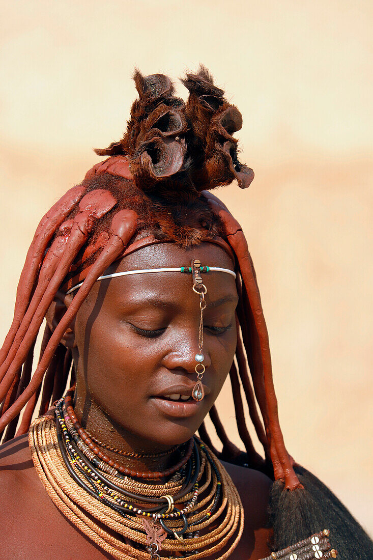 Namibia; Region Kunene; Nordnamibia; Kaokoveld; bei Epupa; Dorf am Kunene Fluss; Himba Frau mit traditioneller Haartracht und Schmuck