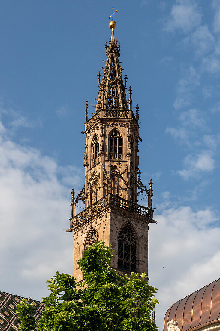 Cathedral bell tower under clouded sky, Bolzano, South Tyrol, Italy