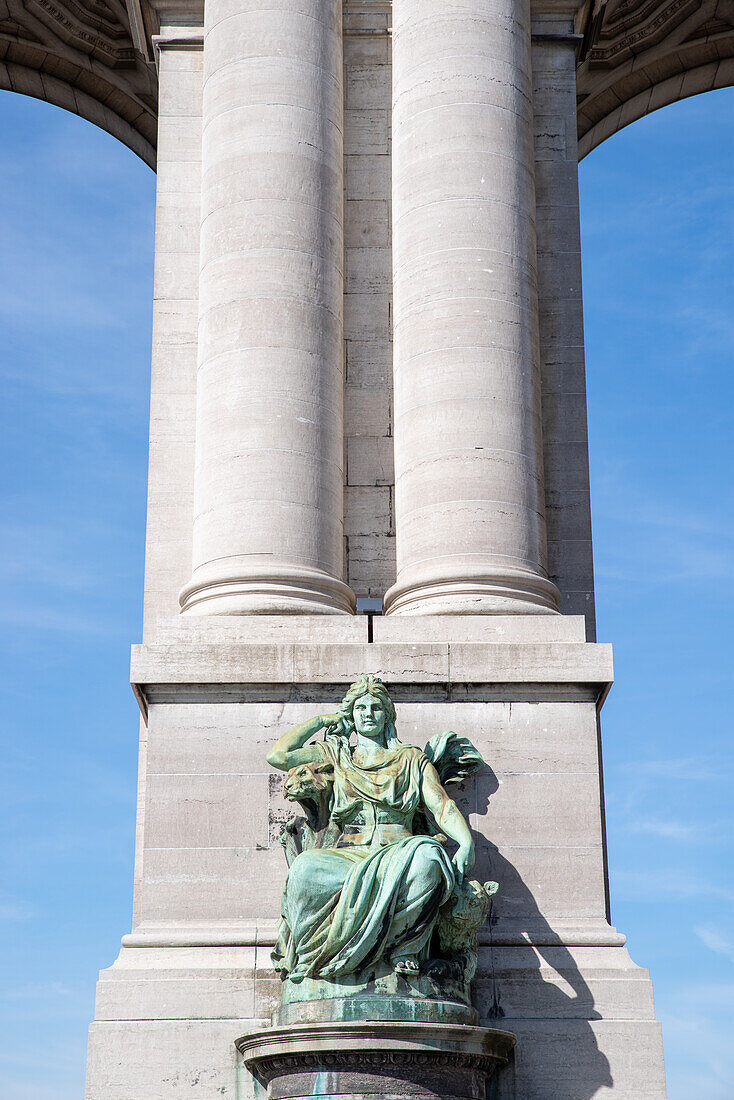 Statue sitting at bottom of column at the Monument du Cinquantenaire in Brussels, Belgium