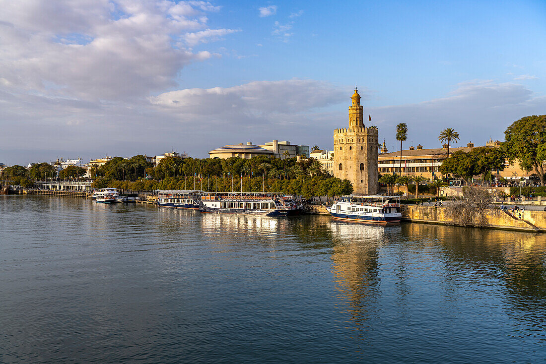 On the banks of the Guadalquivir River with the historic Torre del Oro tower in Seville, Andalusia, Spain
