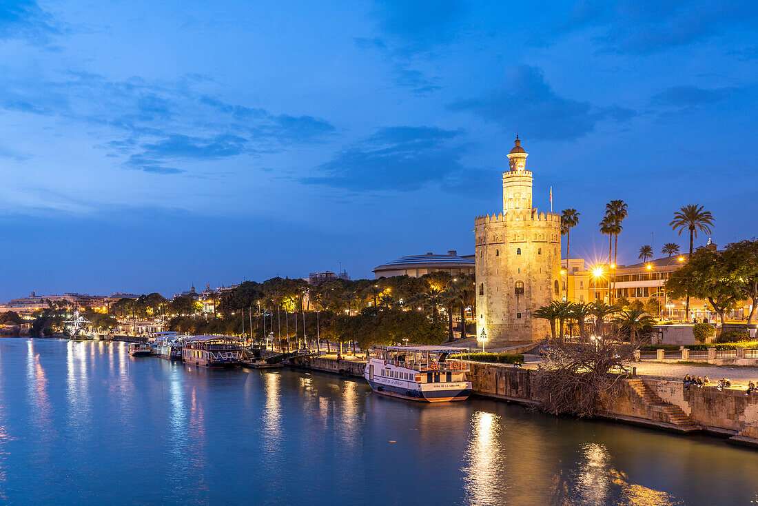 Am Ufer des Fluss Guadalquivir mit dem historischen Turm Torre del Oro in der Abenddämmerung, Sevilla, Andalusien, Spanien 