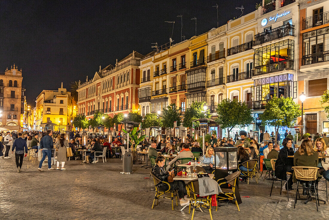 Crowded restaurants and bars in Plaza de San Francisco at night, Seville, Andalusia, Spain
