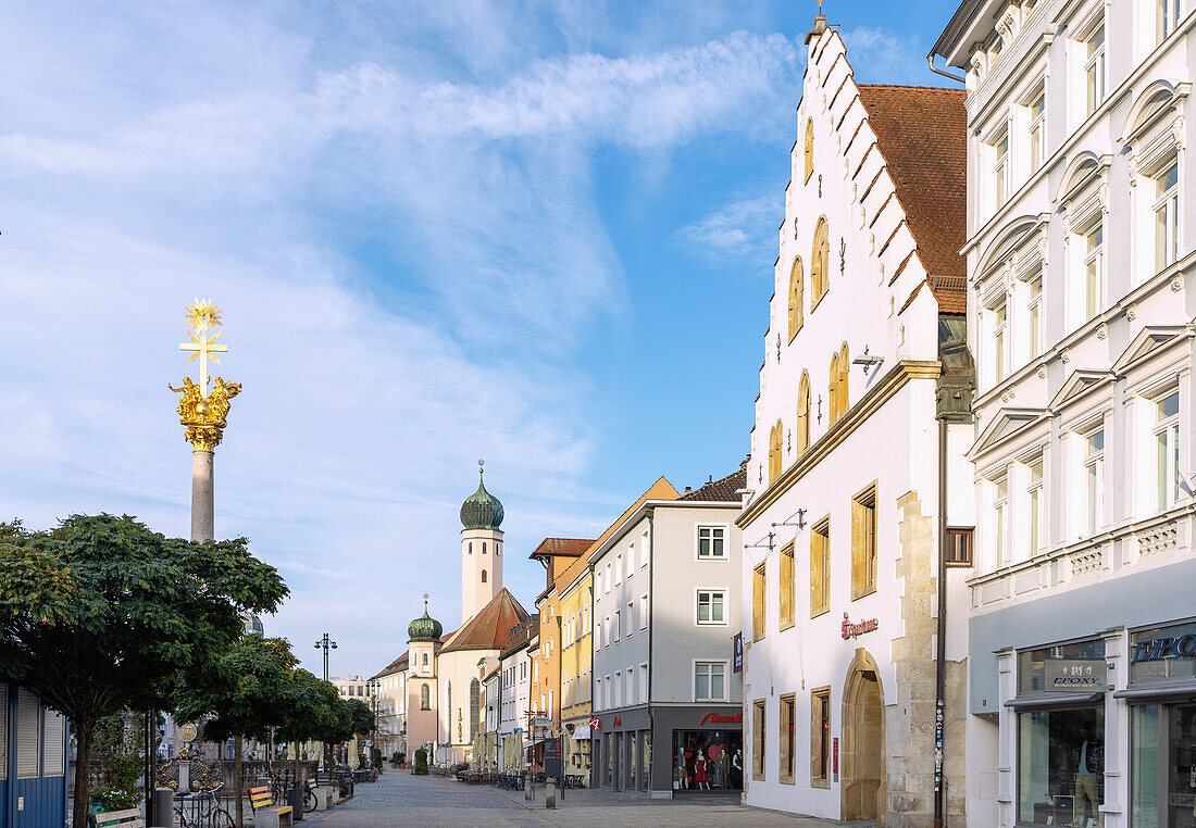 Theresienplatz mit Dreifaltikeitssäule, Eckhaus mit neogotischem Treppengiebel und Blick auf ehemalige Jesuitenkirche in Straubing in Niederbayern in Deutschland