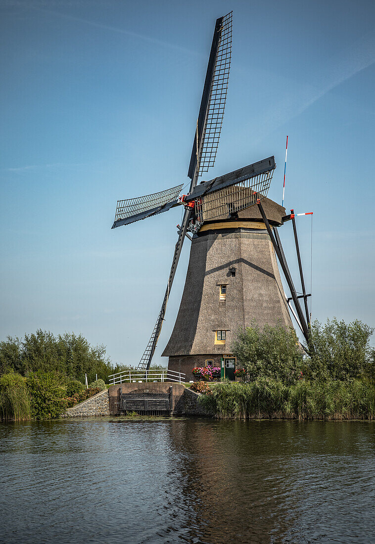 Windmill of Kindedijk in the Netherlands on the water with the blue sky in the background