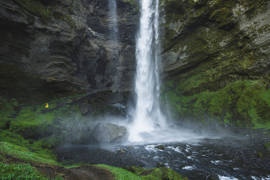 Frau am Wasserfall Kvernufoss in Island
