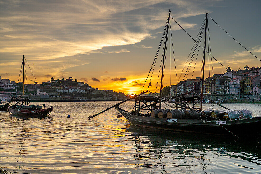 Mit Portweinfässern beladene Rabelo Boote am Douro Ufer bei Sonnenuntergang, Porto, Portugal, Europa