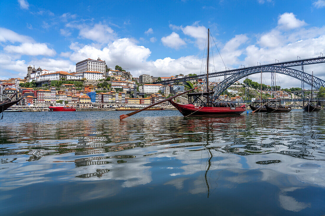 View across the traditional Rabelo boats on the Douro river bank in Vila Nova de Gaia to the old town of Porto and the Dom Luís I bridge, Vila Nova de Gaia, Portugal, Europe