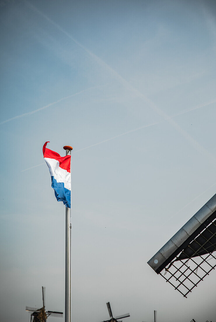 The Netherlands flag with windmills in the background