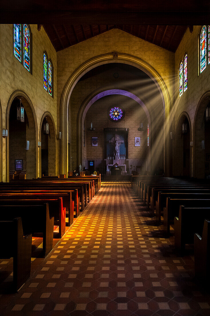 Golden light of sunrays coming into the stained glass windows of St Leo's Abbey in Florida