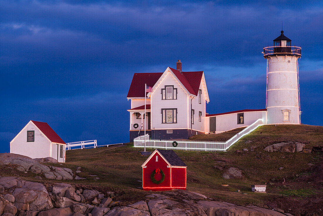 USA, Maine, York Beach, Nubble Light Lighthouse mit Weihnachtsschmuck in der Abenddämmerung