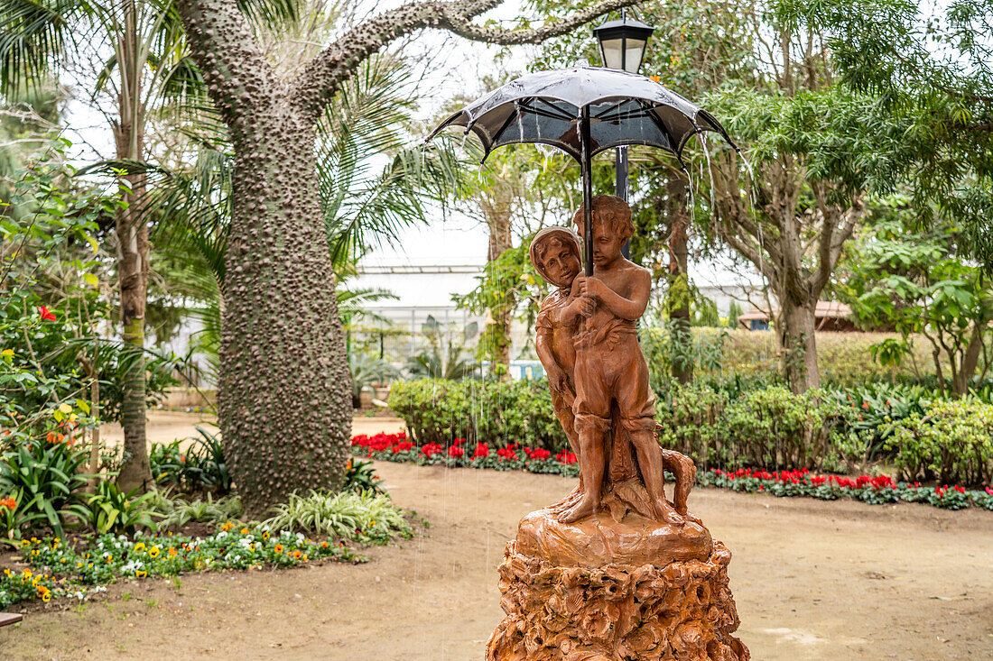Fuente de los Niños del Paraguas fountain with two children under an umbrella in Parque Genovés park, Cadiz, Andalusia, Spain