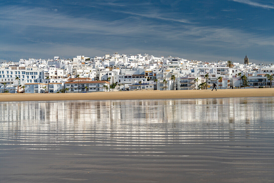 Conil cityscape reflected on Playa De Los Bateles beach, Conil de la Frontera, Costa de la Luz, Andalusia, Spain