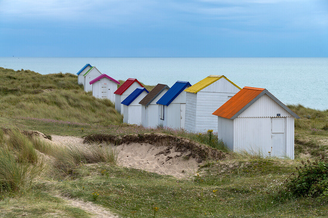 Bunte Strandhäuser in den Dünen am Strand von Gouville-sur-Mer, Normandie, Frankreich
