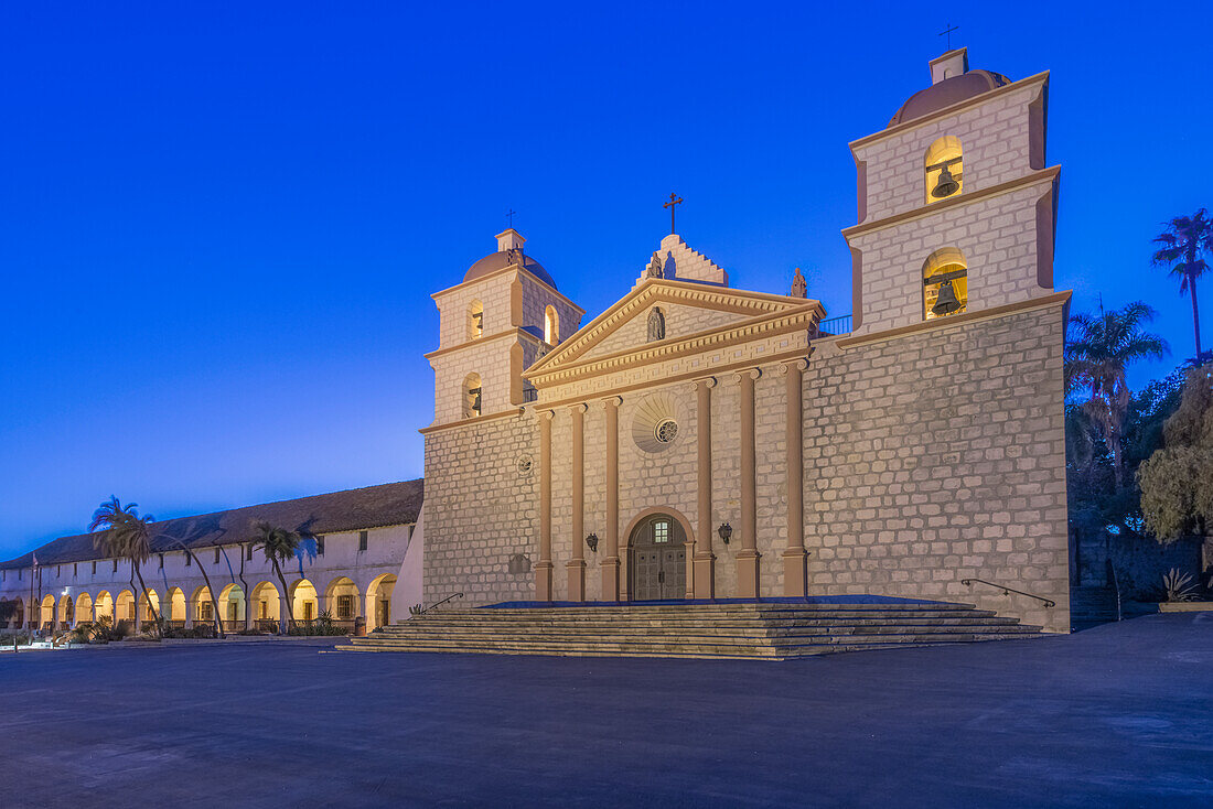 Mission Santa Barbara church lit up at dusk.