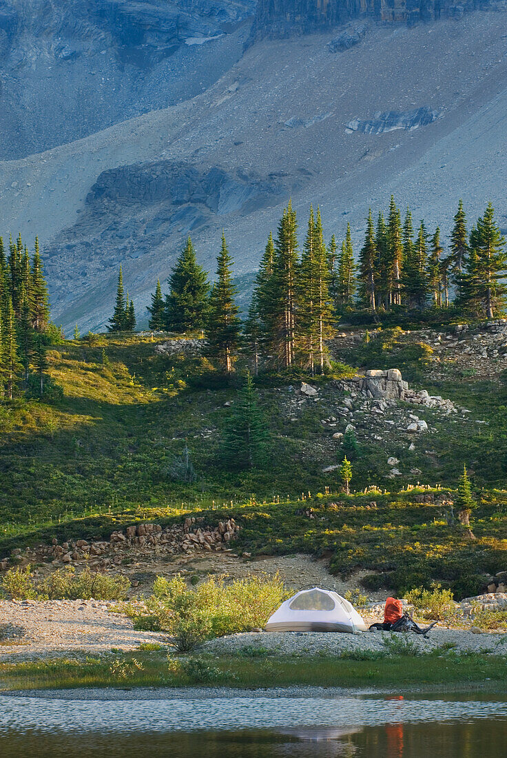 Ein kleines weißes Zelt und Rucksack am Ufer eines Sees im Yoho-Nationalpark.