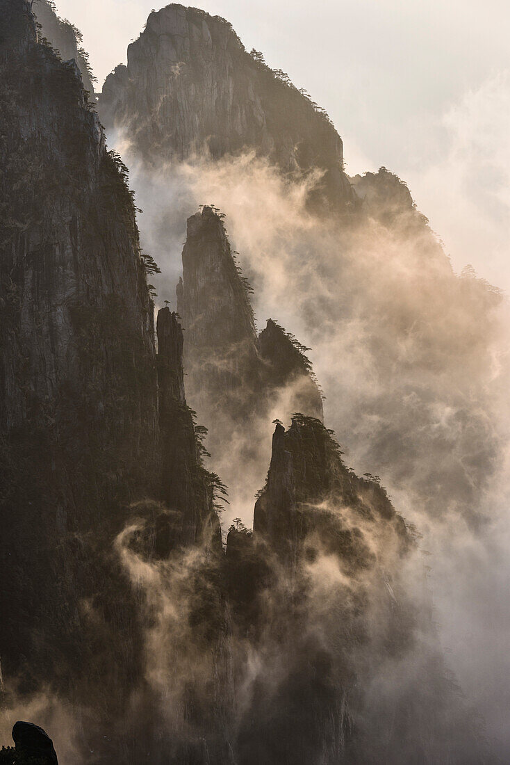 Die steilen, zerklüfteten Granitgipfel der Huangshan-Berge, der Gelben Berge, Nebel und Wolken in den Tälern zwischen den Gipfeln.