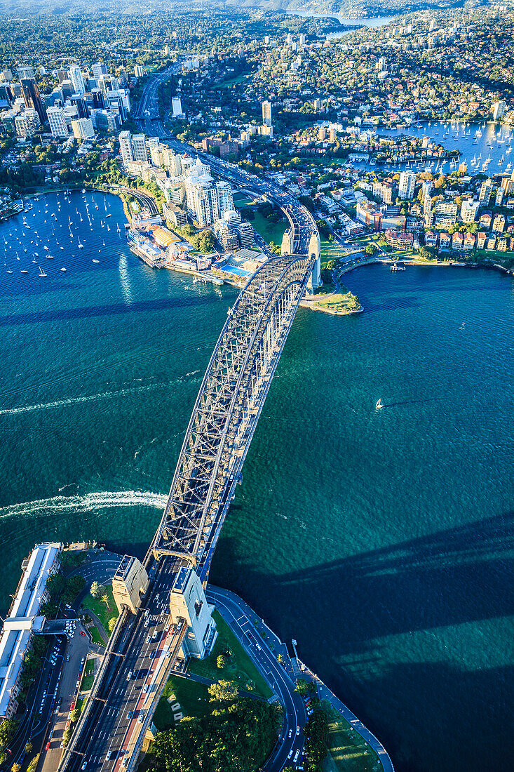 Blick von oben auf die Sydney Harbour Bridge und die Stadt Sydney, die Innenstadt und die Uferpromenade.