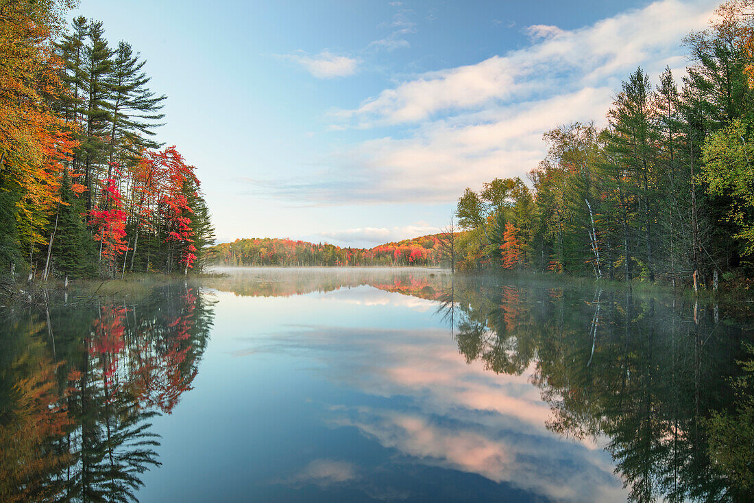 Herbstfarben und Nebel reflektieren Council Lake bei Sonnenaufgang, Hiawatha National Forest, obere Halbinsel von Michigan.