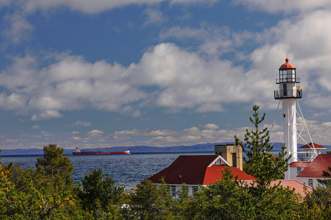 Freighter bound for Canada passing Whitefish Point Lighthouse, the oldest operating light on Lake Superior, Upper Peninsula, Michigan