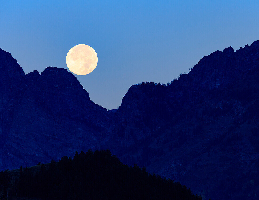 Super moon setting over the Grand Teton Mountain Range, Grand Teton National Park, Wyoming