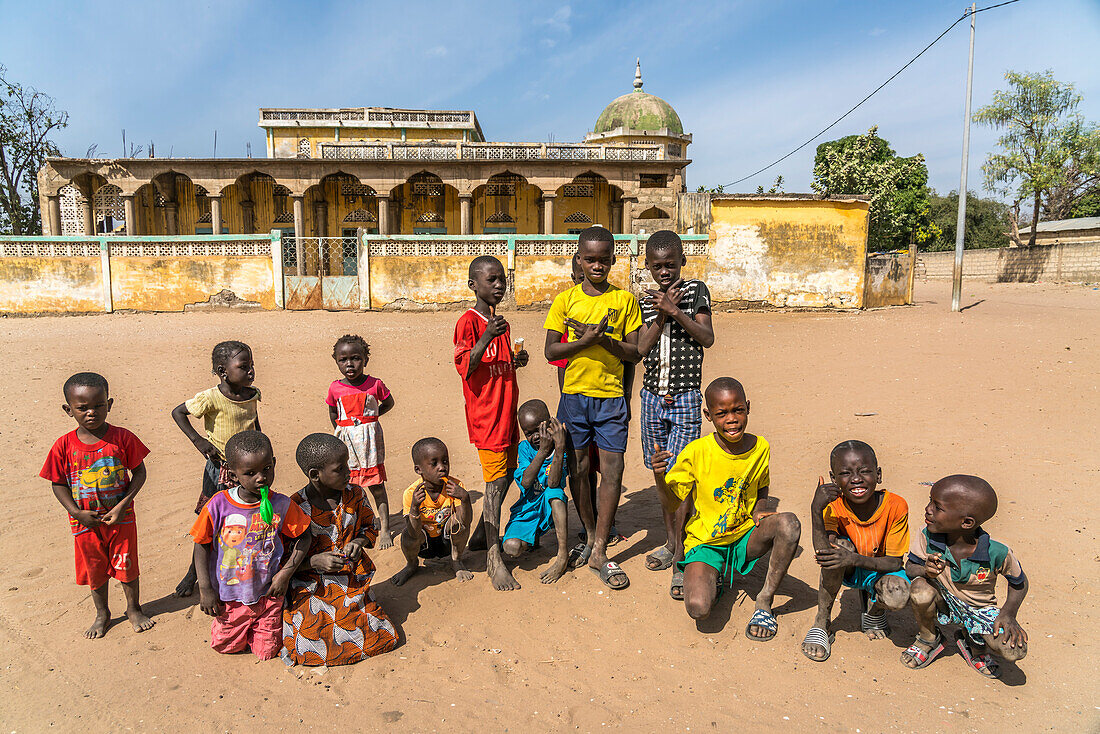 a group of african children posing in front of the mosque in Missirah, Sine Saloum Delta, Senegal, West Africa,