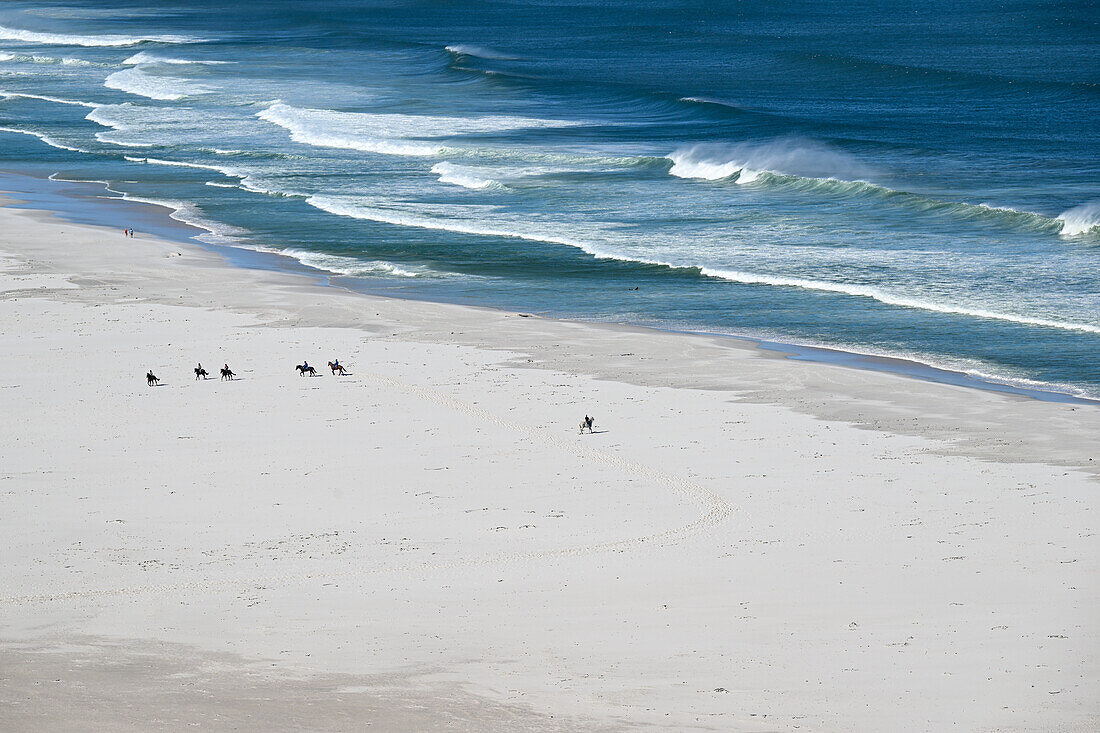 Reiter auf Pferden am Strand von Nordhoek, Western Cape, Südafrika