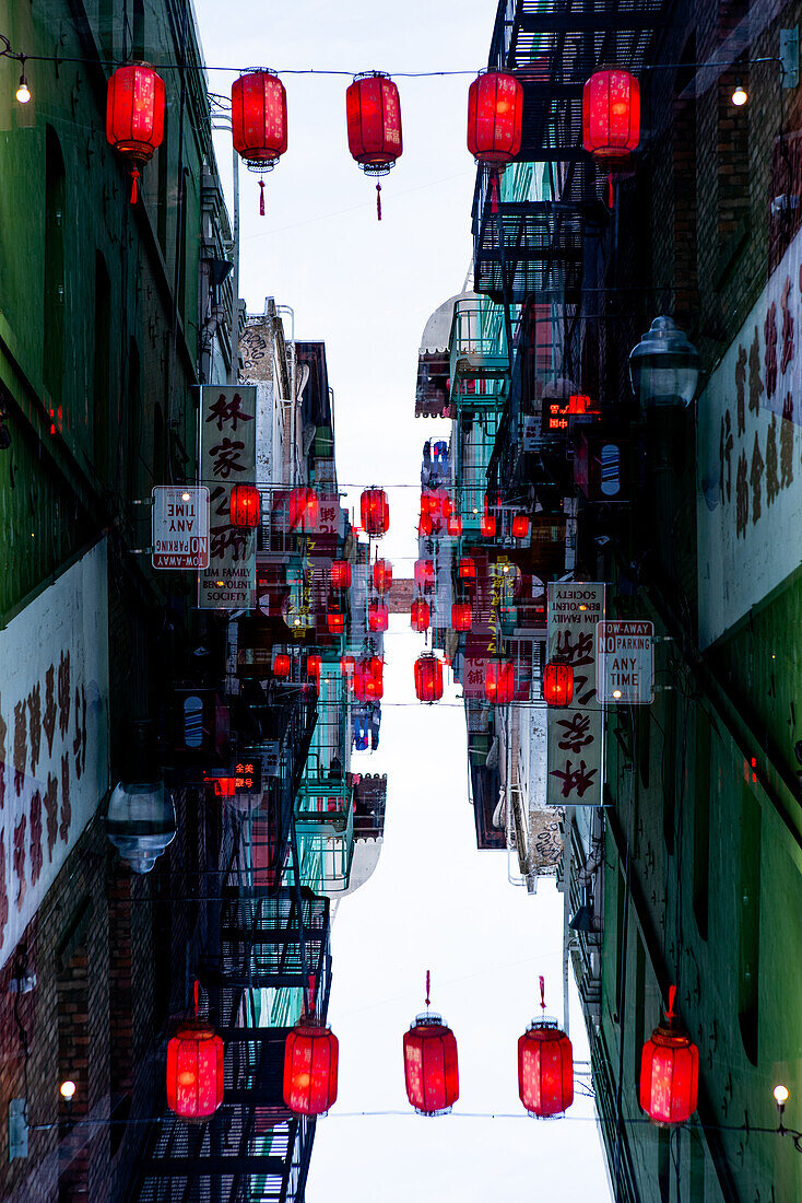 Doppelbelichtung der Ross Alley mit Gebäuden mit chinesischen Schriftzügen und chinesischen Laternen auf der Grant Avenue in Chinatown, San Francisco.
