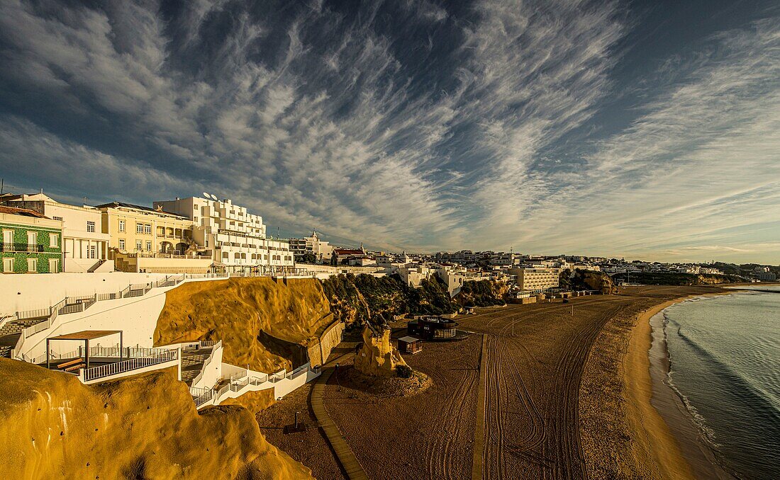 Praia do Peneco, Rochedo Peneco and the stairs from the beach to the old town in the light of the morning sun, Albufeira, Algarve, Portugal