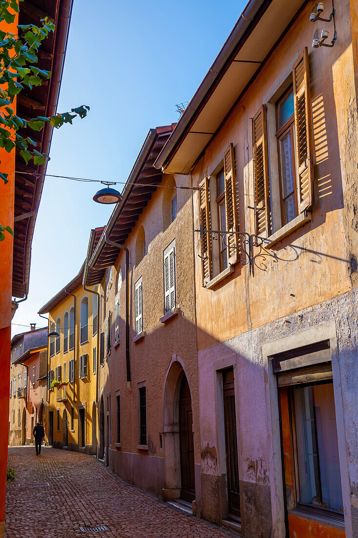 Gasse mit alten Häusern an einem sonnigen Tag in Arzo, Tessin, Schweiz.