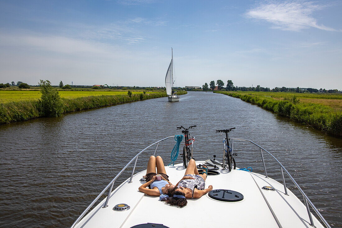 Junge erwachsene Tochter und Mutter an Deck von einem Le Boat Elegance Hausboot auf dem Fluss Nieuw Wijmerts, Woudsend, Friesland, Niederlande, Europa