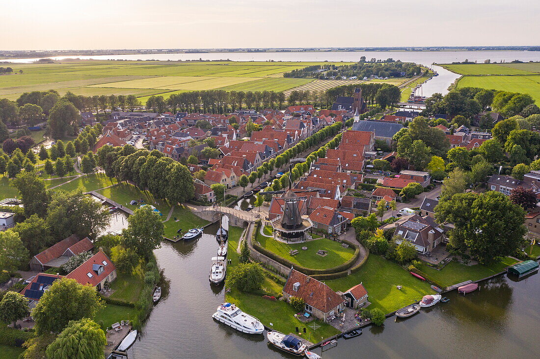 Luftaufnahme von Le Boat Elegance Hausboot am Stadtanleger vor Windmühle De Kaai bei Sonnenuntergang, Sloten, Friesland, Niederlande, Europa