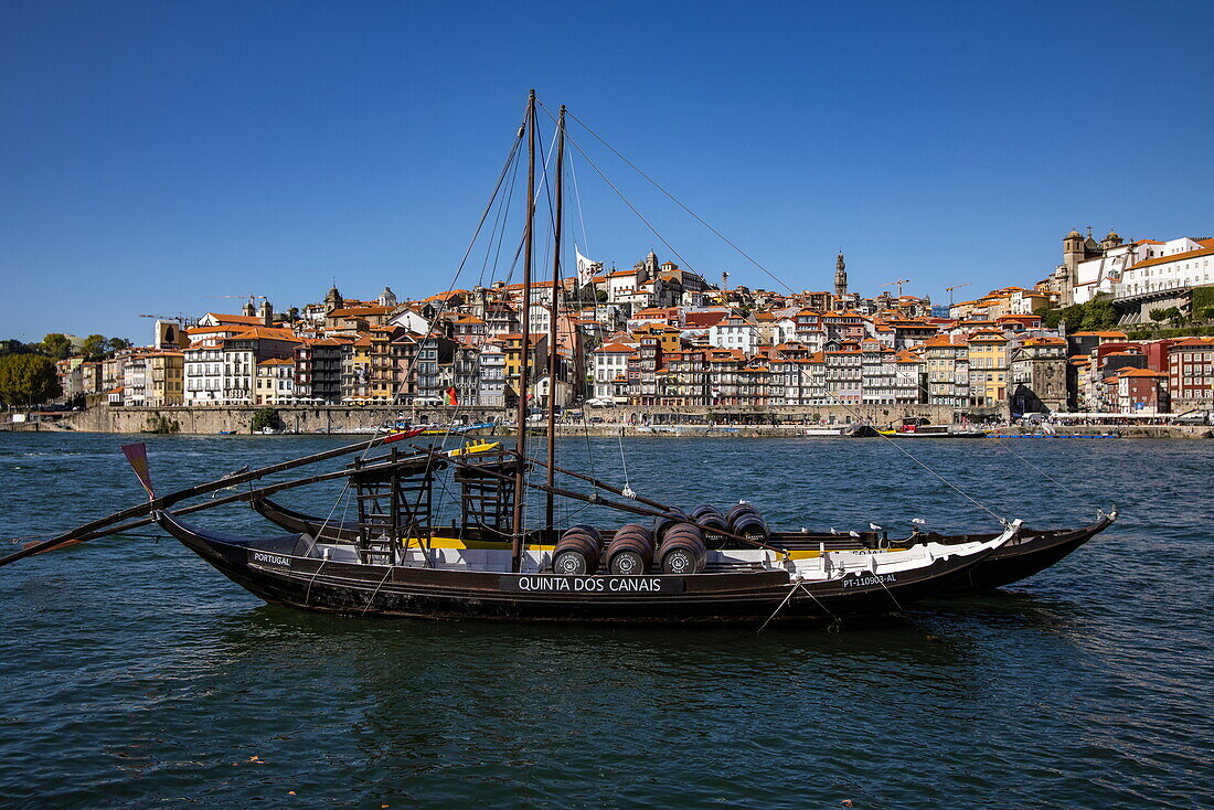 Traditionelles Portwein-Transportboot auf dem Fluss Douro mit Blick auf die Altstadt von Ribeira und das historische Zentrum, Vila Nova de Gaia, Porto, Portugal, Europa