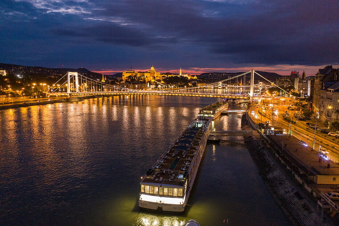 Aerial view from river cruise ship Excellence Empress (Mittelthurgau travel agency) overlooking Szechenyi Chain Bridge over Danube River and Fisherman's Bastion at night, Budapest, Pest, Hungary, Europe