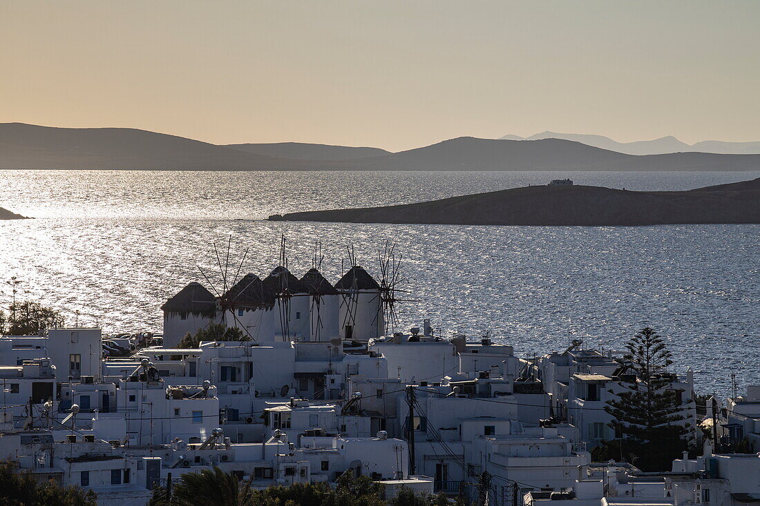 Blick über Stadt mit den Windmühlen von Mykonos und Inseln in der Ferne bei Sonnenuntergang, Mykonos, Südliche Ägäis, Griechenland, Europa