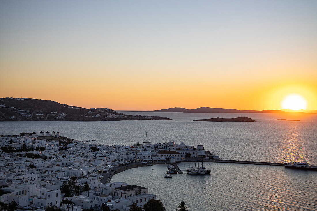Blick über die Stadt mit den berühmten Windmühlen von Mykonos, Hafen und Inseln bei Sonnenuntergang, Mykonos, Südliche Ägäis, Griechenland, Europa