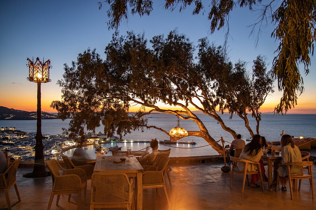 Menschen chillen in der 180º Sunset Bar mit Blick auf die Stadt und die Inseln in der Abenddämmerung, Mykonos, Südliche Ägäis, Griechenland, Europa