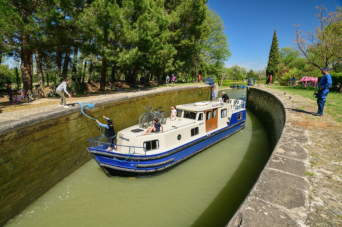 Boat passes through Ecluse de l'39; Aiguille lock, Canal du Midi, UNESCO World Heritage Canal du Midi, Occitania, France