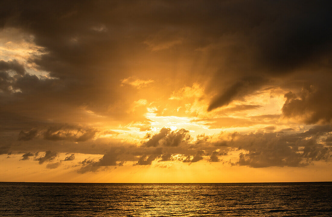 Orangefarbene Wolken über dem Meer bei Sonnenaufgang