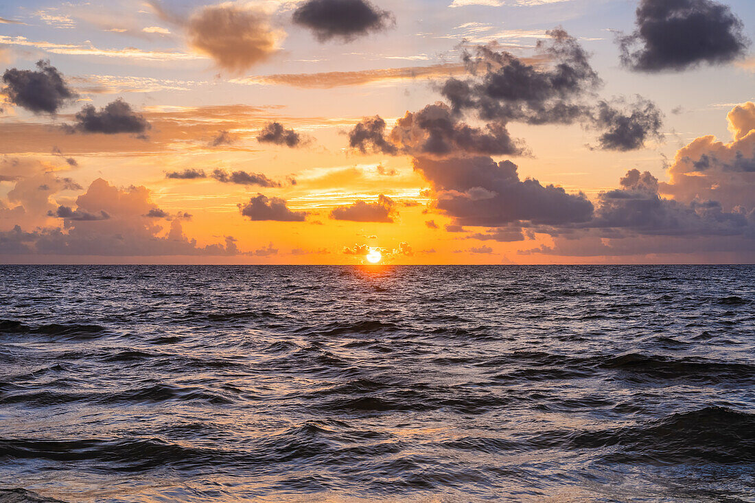 Goldene Wolken über dem Meer bei Sonnenaufgang