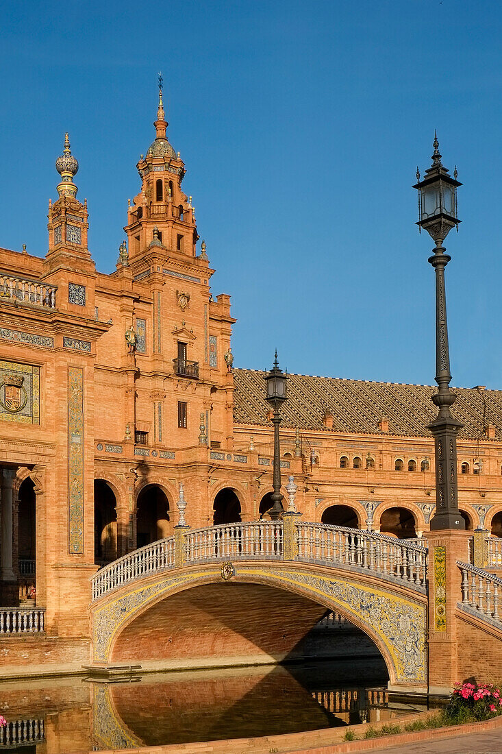 Spain, Seville, Arch bridge over canal and brick church in background