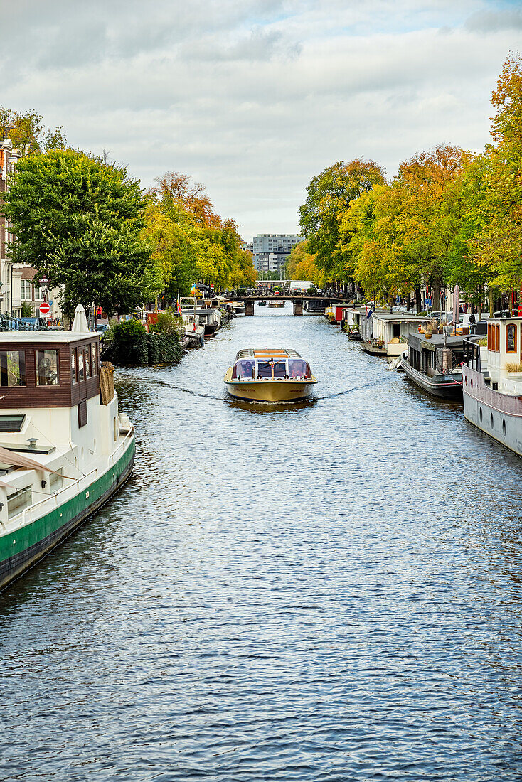 Boote und Ausflugsboot auf einem Kanal, Amsterdam, Holland