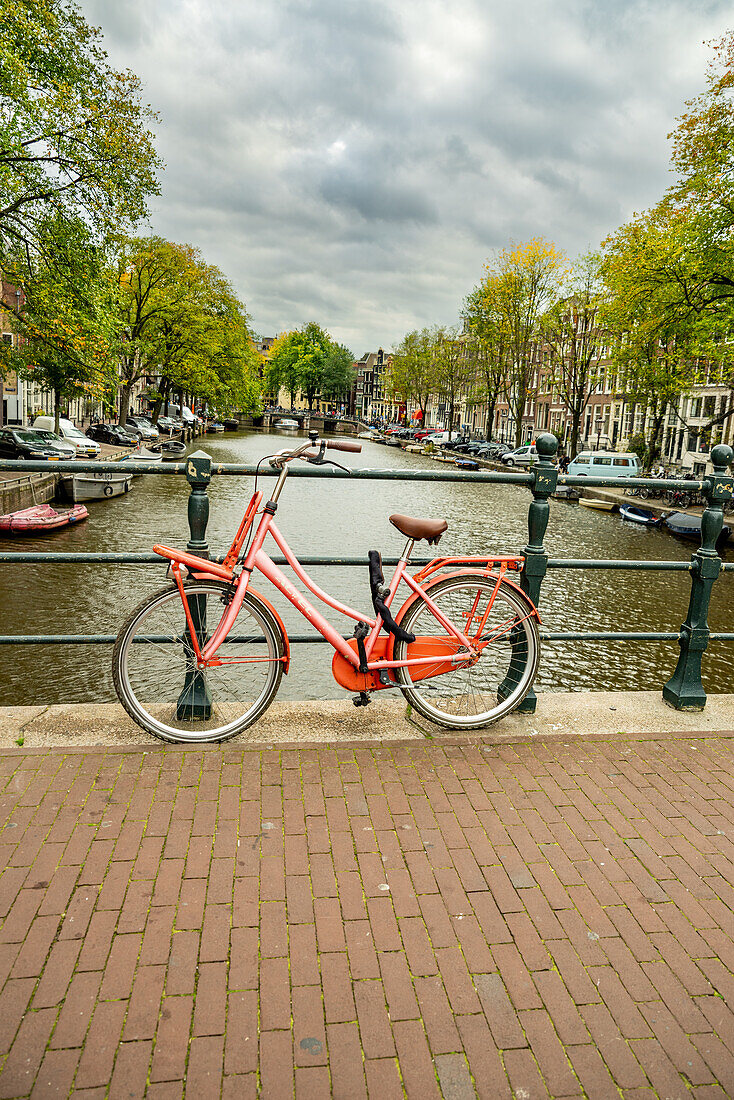 Hollandrad an Geländer gekettet auf Kanalbrücke, Amsterdam, Holland
