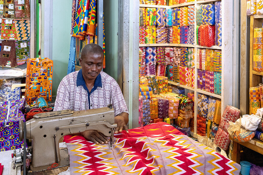 Tailors for traditional kente fabrics in the central market in Kumasi in the Ashanti region of central Ghana in West Africa
